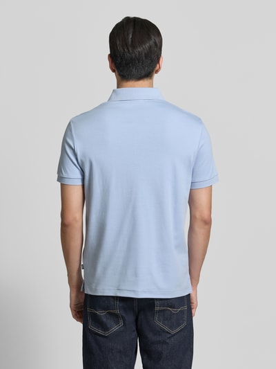 Männermodel trägt hellblaues Modern Fit Poloshirt mit Logo-Stitching Modell 'Primo' von JOOP! Collection, Reine Baumwolle, Ganzkörperansicht Rückansicht.