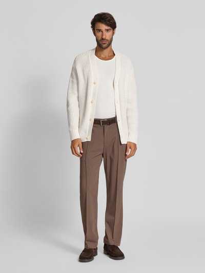 Männermodel trägt Regular Fit Strickjacke aus reiner Baumwolle Modell 'DERECK' von SELECTED HOMME in Creme, Grobstrick, Ganzkörperansicht von vorne.