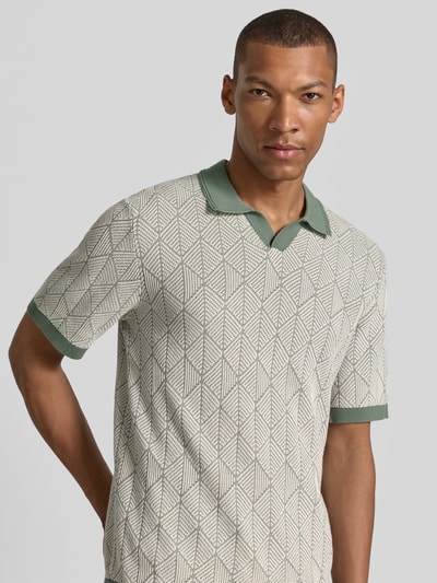 Männermodel trägt Slim Fit Poloshirt in Strick-Optik Modell 'Blake' von Jack & Jones Premium aus Reine Baumwolle, Nahaufnahme Oberkörper.