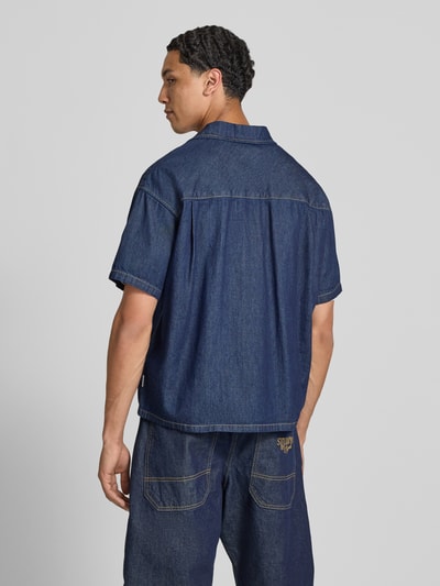Männermodel trägt Modern Fit Jeanshemd mit Brusttasche Modell 'AUSTIN' von Jack & Jones aus reiner gewachster Baumwolle, Rückenansicht.