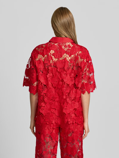 Frauenmodel trägt Regular Fit Bluse aus Spitze Modell 'GALA' von YAS in leuchtend Rot mit floraler Textur, Ganzkörperansicht Rückansicht.