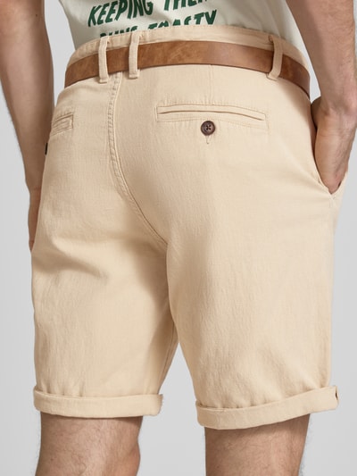 Männermodel trägt Bermudas mit Gürtel und Eingrifftaschen Modell 'NEBRASKA' von Redefined Rebel in Beige, Baumwoll-Mix mit Stretch-Anteil, Straight Fit, Bundweite 46 cm, Innenbeinlänge 21 cm, Gesäßleistentaschen, Ganzkörperansicht Rückansicht.