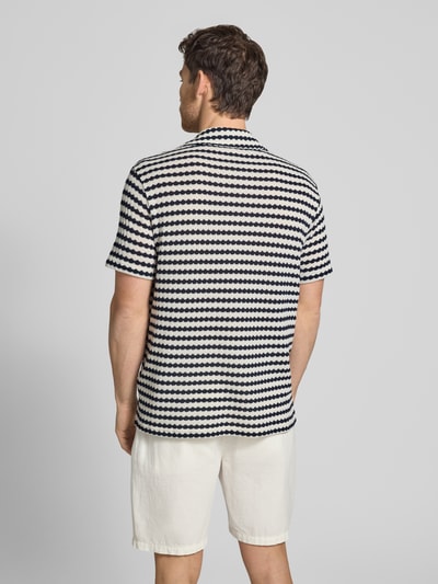 Männermodel trägt Relaxed Fit Poloshirt aus Baumwoll-Mix Modell 'DYLAN' von SELECTED HOMME, Optik: Allover-Muster, Feinstrick, Ganzkörperansicht Rückansicht.