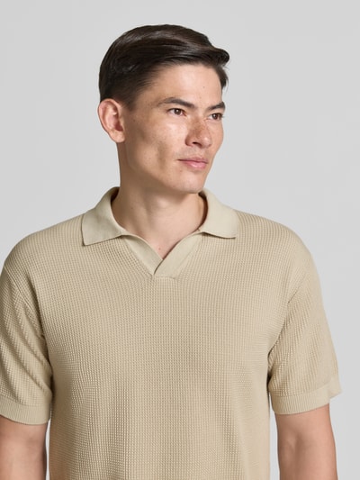 Mannenmodel draagt Regular Fit Poloshirt uit zuivere katoen model 'KOCELLO' van BOSS Orange, beige, structuur breisel, label patch, polokraag, korte mouw, geribde boorden, unilook. Close-up bovenlichaam.