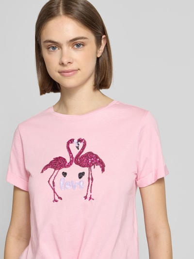 Frauenmodel trägt Regular Fit T-Shirt aus reiner Baumwolle Modell 'DORA LIFE' von Only in Rosa mit Pailletten, Kurzarm, Rundhals, Nahaufnahme Oberkörper.