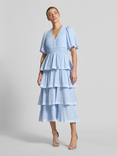 Frauenmodel trägt Midikleid in Rüschen-Optik Modell 'Plira' von YAS, Tailliert, V-Ausschnitt, Halbarm, Strukturmuster, Ganzkörperansicht von vorne.