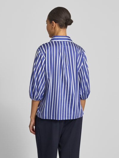Frauenmodel trägt Regular Fit Bluse mit 3/4-Arm von Marc Cain in Blau-Weiß mit Allover-Look aus Reine Baumwolle, Hemdblusenkragen und Knopfleiste, Rückenlänge 62 cm, Ärmellänge 40 cm, Ganzkörperansicht Rückansicht.