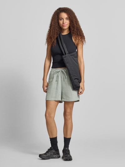 Modelka nosi szorty Relaxed Fit Shorts aus reiner Baumwolle Modell 'THYRA' od Only, efekt: jednolity kolor, materiał: krepa z bawełny, wpuszczane kieszenie, elastyczny ściągacz; widok całej sylwetki z przodu.