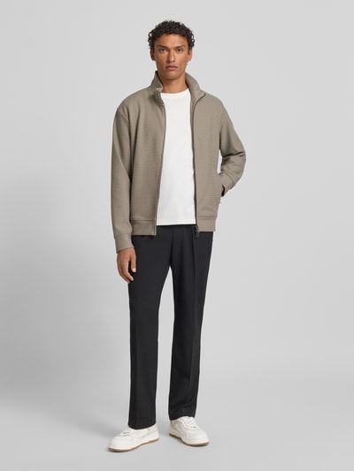 Männermodel trägt Sweatjacke mit Stehkragen von Emporio Armani aus Baumwoll-Lyocell-Mix mit Stretch-Anteil, lockerer Schnitt, Reißverschluss, Eingrifftaschen, gerippte Abschlüsse, Rückenlänge 64 cm, Ärmellänge 60 cm, Ganzkörperansicht von vorne.