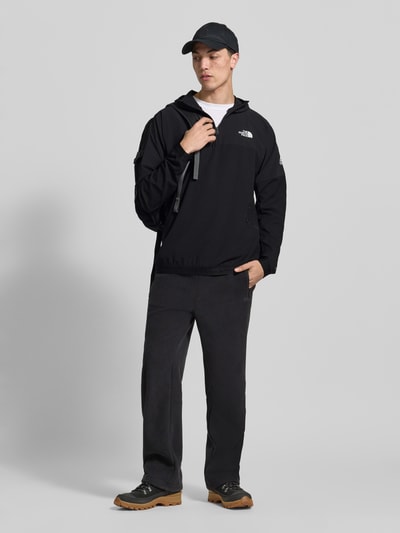Männermodel trägt Hoodie mit Reißverschluss und Logo von The North Face in Schwarz, Regular Fit, Ganzkörperansicht von vorne.