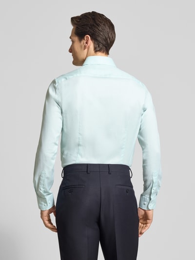 Männermodel trägt Slim Fit Freizeithemd aus Baumwoll-Mix von Tommy Hilfiger, efekt: jednolity kolor, melanż, kołnierzyk typu kent, listwa guzikowa jednorzedowa, detal z logo, pas na plecach, mankiety kombi, wykończenie zaokrąglone, wykończenie materiału: popelina, materiał: mieszanka bawełny, ganzkörperansicht rückansicht