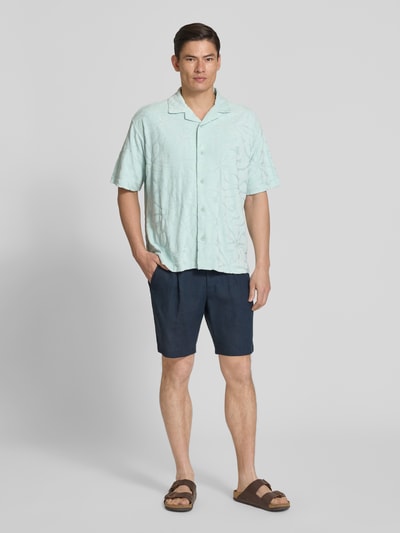 Männermodel trägt Regular Fit Freizeithemd aus Baumwoll-Mix Modell 'WE_FLOWER' von BOSS Orange, unifarben, strukturierte Oberfläche, Kurzarm, Ganzkörperansicht von vorne.