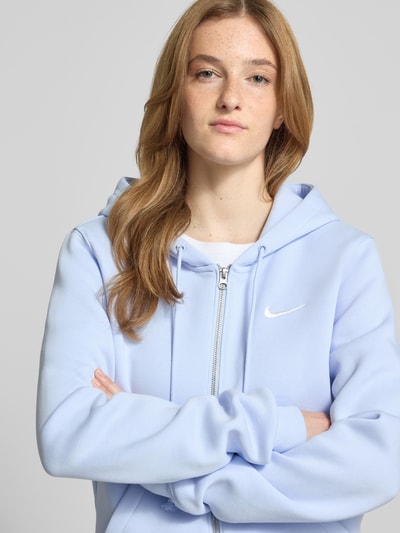 Frauenmodel trägt Regular Fit Sweatjacke mit Logo-Stitching Modell 'Phoenix' von Nike aus Baumwoll-Mix mit Kapuze, Nahaufnahme Oberkörper.