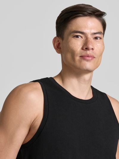Männermodel trägt Relaxed Fit Tank Top aus reine Baumwolle von Armedangels, jednokolorowy, krój relaxed fit, okrągły dekolt, szerokie ramiączka, materiał: bawełna, Nahaufnahme Oberkörper
