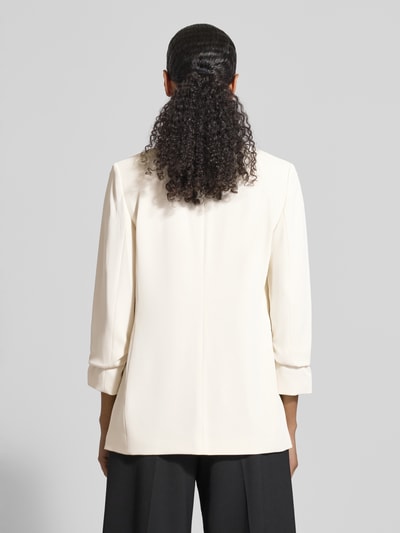 Frauenmodel trägt Blazer mit Pattentaschen von Jake*s Collection, Material-Mix mit Stretch-Anteil, Lockerer-Schnitt, 3/4-Ärmel, Stehkragen, Rückenlänge 69 cm, Brustweite 44 cm, Ärmelänge 52 cm, Farbe Creme, glatte Textur, Ganzkörperansicht Rückansicht.