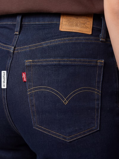 Frauenmodel trägt Straight Fit Jeans aus Baumwoll-Mix mit Lyocell-Anteil Modell '723' von Levi's® 300, dunkelblauer Denim mit gelber Ziernaht, Detailaufnahme Rückansicht.