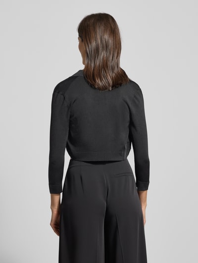 Frauenmodel trägt Bolero mit Schalkragen von Jake*s Cocktail aus schimmerndem Viskosemischung Material, gerippte Abschlüsse, Dreiviertel-Ärmel, Rückenlänge bei Größe 36: 39 cm, Ganzkörperansicht Rückansicht.