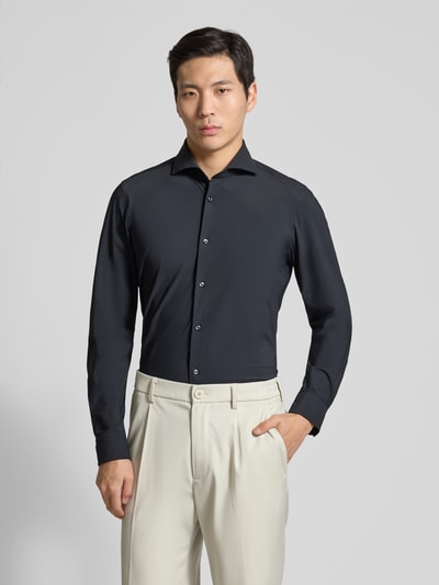 Männermodel trägt Slim Fit Business-Hemd mit Kentkragen von JOOP! Collection, schwarzer Stoff mit Knopfleiste, Ganzkörperansicht von vorne. Material-Mix mit Stretch, langärmelig, Sportmanschetten, abgerundeter Saum, moderne Form.