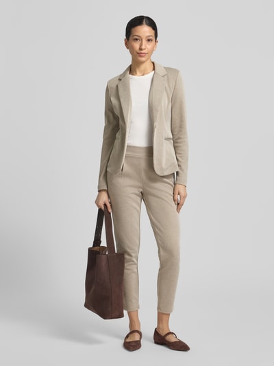Frauenmodel trägt Slim Fit Stoffhose mit elastischem Bund Modell 'Kate' von ICHI aus beigem Baumwoll-Mix, seitliche Paspeltaschen, Ganzkörperansicht von vorne.