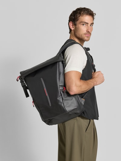 Männermodel trägt Rucksack mit Logo-Detail Modell 'Ecodiver' von Samsonite, schwarze Farbe, breite Schnallen, Ganzkörperansicht Rückansicht. Hauptfach mit Schnallenverschlüssen, verstellbare Schulterriemen, Maße 42x50x19 cm, Länge Schulterriemen 62 cm.