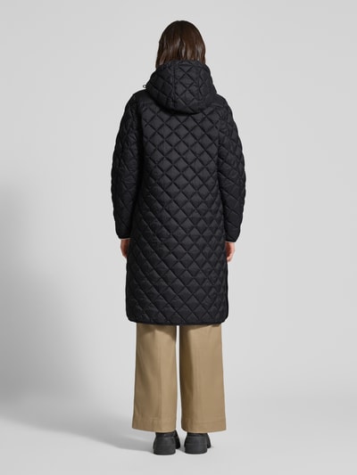 Vrouwenmodel draagt zwarte Straight Fit Steppmantel Modell 'Philia' van CINQUE met capuchon en steekzakken, rechte rugaanzicht.