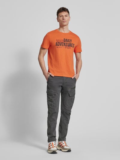 Męski model nosi Spodnie cargo z wyhaftowanym logo od PME Legend, mieszanka bawełny i elastanu, krój slim fit, kieszenie cargo, szerokość w rozmiarze 32/32: 44 cm, długość wewnętrzna nogawki 77 cm, widok całej sylwetki z przodu