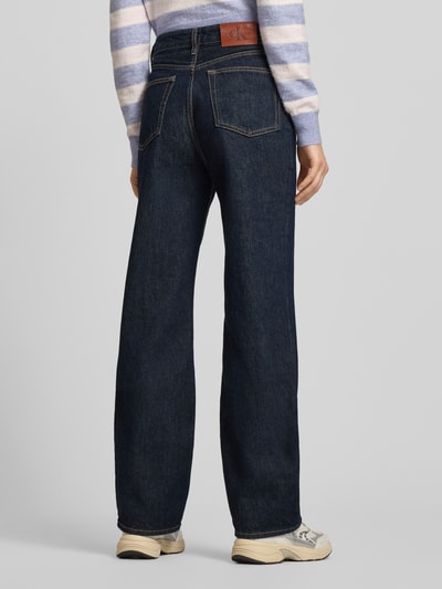 Frauenmodel trägt Straight Fit Jeans mit Label-Detail von Calvin Klein Jeans aus reiner Baumwolle, dunkler Denim, Ganzkörperansicht Rückansicht. Modell "THE STRAIGHT BOOT RESIN", Bundweite 37 cm, Innenbeinlänge 80 cm.