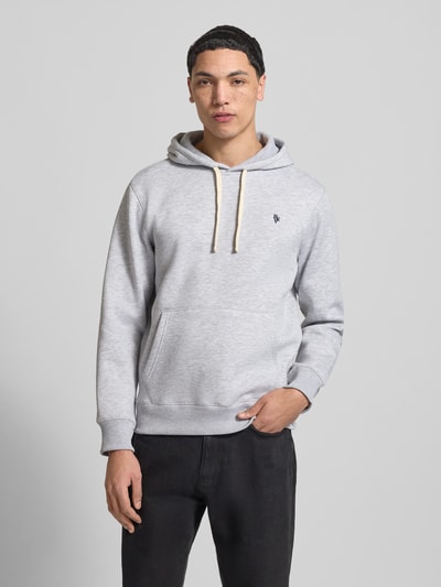 Männermodel trägt Slim Fit Hoodie mit Logo-Stitching van REVIEW aus katoenmix, kangoeroezak, capuchon met tunnelkoord, elastische boorden, slim fit. Ganzkörperansicht von vorne.