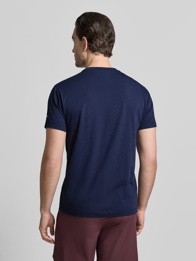 Męski model nosi Regular Fit T-Shirt mit Rundhalsausschnitt od Fabletics, bawełniany miks z modalem, granatowy, krótki rękaw, długość tyłu 70 cm, krój regular fit, widok całej sylwetki z tyłu.