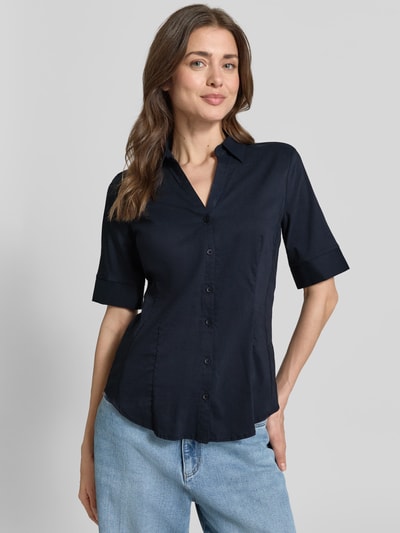 Frauenmodel trägt Hemdbluse im Halbarm-Design von More & More in Dunkelblau, taillierte Passform, Baumwoll-Mix, Knopfleiste, Ganzkörperansicht von vorne. Rückenlänge bei Größe 36: 65 cm, Ärmellänge: 28 cm, Hemdblusenkragen.