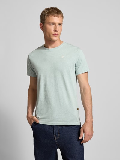 Männermodel trägt Regular Fit T-Shirt aus reiner Baumwolle von G-Star in Melange-Optik mit Label-Patch, Rundhals, Kurzarm, Jersey, Ganzkörperansicht von vorne. Brustweite 53 cm, Rückenlänge 74 cm bei Größe M.