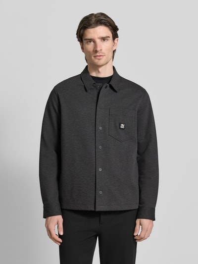 Männermodel trägt Oversized Hemdjacke aus Baumwoll-Mix Modell 'ENASO' von HUGO, melange-grau, unifarben, Twill-Textur, Ganzkörperansicht von vorne.