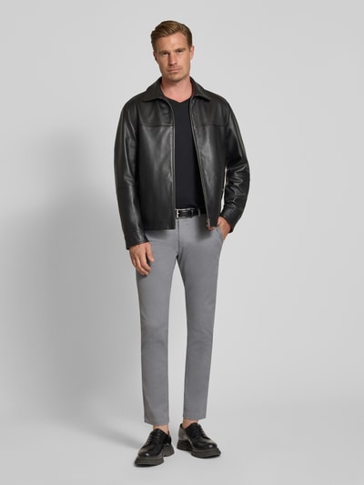 Männermodel trägt Slim Fit Chino aus Baumwoll-Mix von bugatti in Grau, elastisch, mit Münztasche und Gesäßtaschen, Ganzkörperansicht von vorne.
