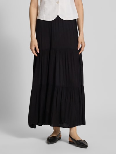 Frauenmodel trägt Ausgestellter Maxi-Rock aus reiner Viskose Modell 'MIKKA' von Only in Schwarz mit Crinkle-Struktur und Volants, Nahaufnahme Unterkörper.