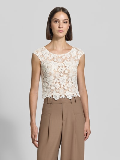 Frauenmodel trägt Cropped Spitzentop mit Rundhalsausschnitt von Luxuar, weiße Spitze, Slim Fit, kombiniert mit beigen Stoffhosen, Ganzkörperansicht von vorne. Rückenlänge bei Größe 36: 36 cm.