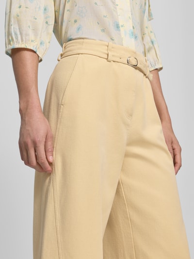 Vrouwenmodel draagt stoffen broek met riem en steekzakken van JAKE*S STUDIO WOMAN, puur katoen, uitlopend model, detailopname heup.