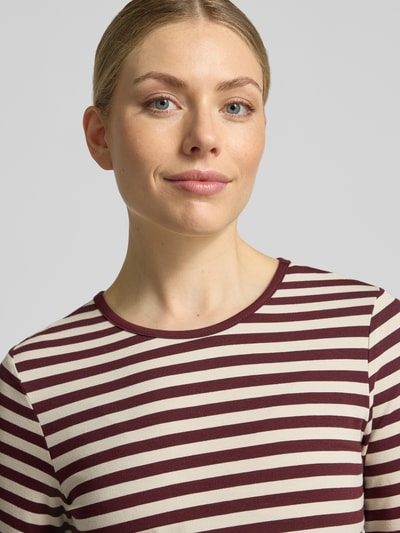 Frauenmodel trägt Skinny Fit Longsleeve aus Viskose-Elasthan-Mix Modell 'Liana' von FREE/QUENT in Creme-Bordeaux gestreift, Nahaufnahme Oberkörper. Damen Longsleeve Viskose-Elasthan-Mix, Rundhalsausschnitt, Rückenlänge bei Größe S 61 cm.