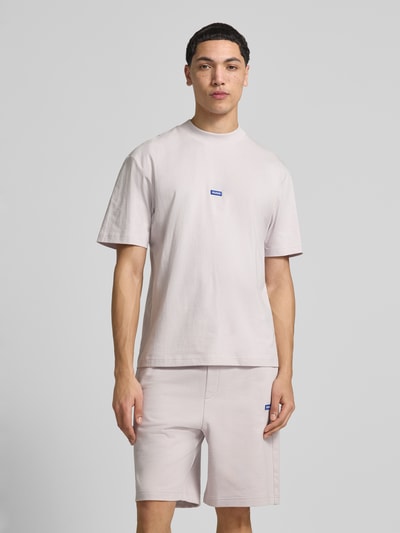 Männermodel trägt Regular Fit T-Shirt aus reiner Baumwolle Modell 'Niereos' von HUGO in Optik: Unifarben mit Label-Patch, Jersey, Rundhals, Kurzarm, Ganzkörperansicht von vorne.