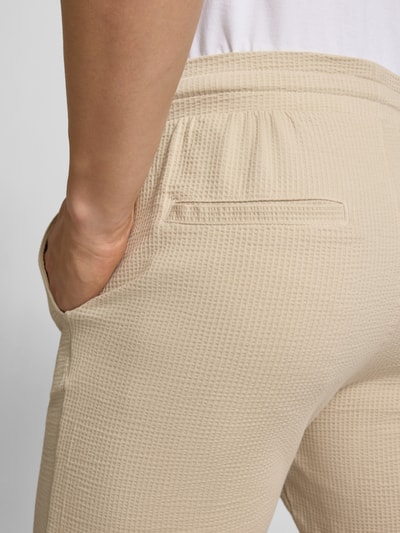 Männermodel trägt Loose Fit Sweatshorts aus Bio-Baumwoll-Mix Modell 'KIAN' von Only & Sons, Optik: Unifarben, Materialverarbeitung: Piqué, Detailaufnahme Rückansicht.