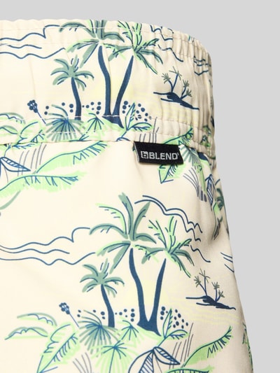 Produktfoto, Badehose mit Label-Detail Modell 'BHRANDALE' von Blend, Loose-Fit, elastischer Bund mit Kordelzug, Herren, tropische Muster, cremefarbener Stoff mit grünen und blauen Palmen, Kontext: Herren Badehose von Blend, Label-Detail