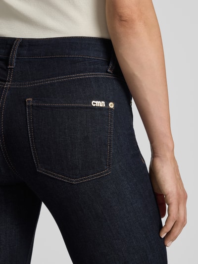 Kobieta nosi ciemnogranatowe jeansy Slim Fit Jeans aus Baumwoll-Mix Modell 'PIPER LONG' von CAMBIO, tekstura gładka, detal tylnej kieszeni, damskie jeansy slim fit, z kolekcji Damen Slim Fit Jeans von CAMBIO, detal tylnej części ciała, zbliżenie