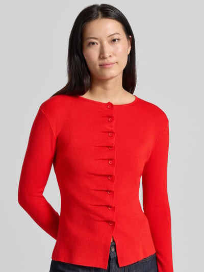 Vrouwenmodel draagt mouwloos vest Model 'GAMIRA' van SUNCOO PARIS in rood, Materiaalmix met linnen, slim fit, ronde hals, plooien, knoopsluiting, ruglengte maat S 56 cm, mouwlengte maat S 61 cm, close-up bovenlichaam.