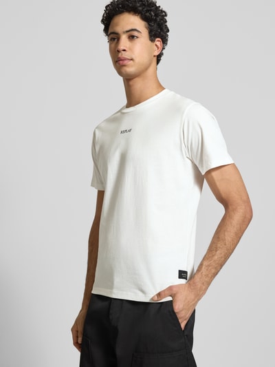 Männermodel trägt Regular Fit T-Shirt mit Logo-Print von Replay, Herren T-Shirt aus reiner Baumwolle, Rundhalsausschnitt, helle Farbe, Ganzkörperansicht von vorne.