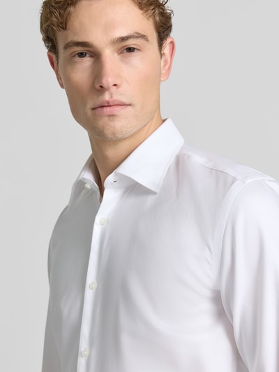 Männermodel trägt weißes Slim-Fit Businesshemd aus reiner Baumwolle Modell 'H-HANK-K' von BOSS, Nahaufnahme Oberkörper, Herren Businesshemd.