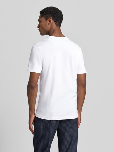 Męski model nosi Regular Fit T-Shirt mit Logo-Stitching od MCNEAL, czysta bawełna, krój regular fit, kolor biały, zdjęcie całej sylwetki z tyłu.
