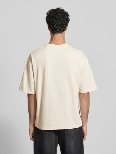 Männermodel trägt Oversized Fit T-Shirt mit Logo-Stitching von REVIEW, florales Stitching, reine Baumwolle, Ganzkörperansicht Rückansicht
