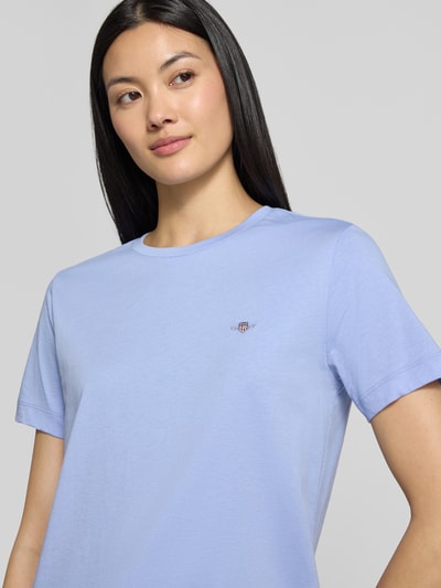 Vrouwenmodel draagt Regular Fit T-Shirt aus reiner Baumwolle van GANT in lichtblauw, gladde textuur, Dames t-shirt, detailopname bovenlichaam.