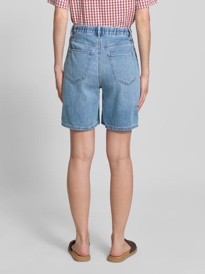 Frauenmodel trägt Regular Fit Bermudas aus Baumwoll-Lyocell-Mix Modell 'VILLA' von Vero Moda, Denim-Optik, 5-Pocket-Design, Ganzkörperansicht Rückansicht.