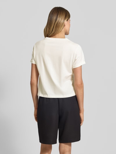 Frauenmodel trägt T-Shirt mit Motiv-Print von Marc Cain in Creme, lockerer Schnitt aus reiner Baumwolle, Rückansicht, Ganzkörperansicht.