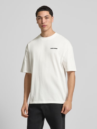 Männermodel trägt Oversized T-Shirt mit Logo-Stitching von Pegador in Weiß, Reine Baumwolle, Oversized-Fit, Rundhalsausschnitt, Ganzkörperansicht von vorne.